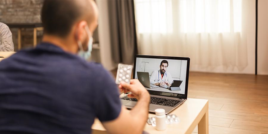 Man, consulting doctor via laptop.